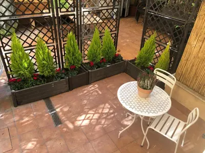 a patio with a table and chairs and plants at Secret Garden in Rome in Rome