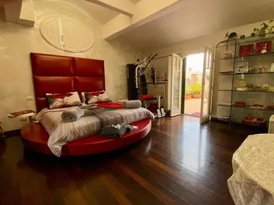 a bedroom with a large bed with a red headboard at Ave Roma Suite in Rome