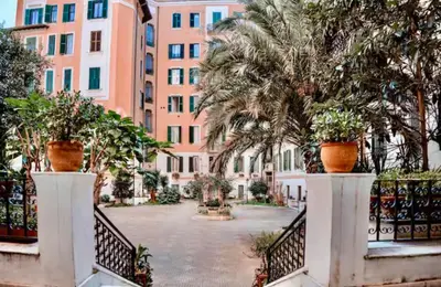 a courtyard in front of a building with palm trees at Ave Roma Suite in Rome