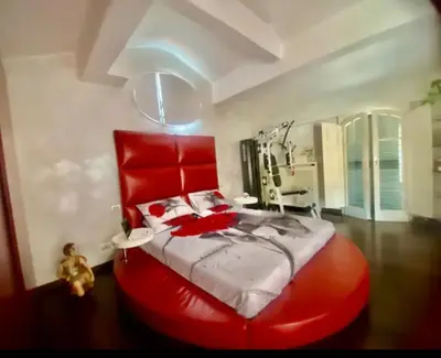a large red bed with a red headboard in a bedroom at Ave Roma Suite in Rome