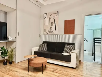 a living room with a black couch and a table at Boutique Trevi Apartment in Rome