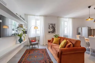 a living room with a brown couch and a kitchen at Great Opera a Via Palermo in Rome