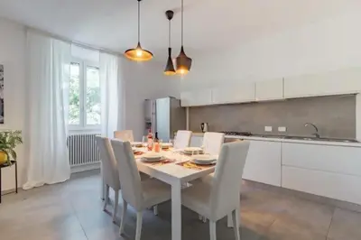 a kitchen with a white table and chairs in a room at Great Opera a Via Palermo in Rome