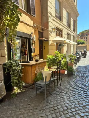 an outdoor cafe with chairs and tables and an umbrella at Domus Antica Navona in Rome