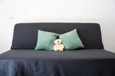 a teddy bear sitting on a couch with two pillows at Garbatella Bridge Apartment in Rome