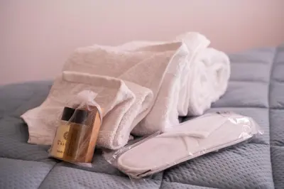 a pile of towels and a bottle of soap on a bed at Garbatella Bridge Apartment in Rome
