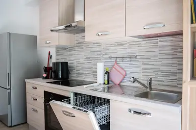 a kitchen with a sink and a dishwasher at Garbatella Bridge Apartment in Rome