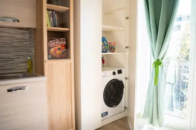 a laundry room with a washer and dryer next to a window at Garbatella Bridge Apartment in Rome