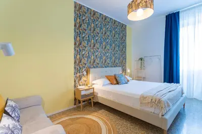 a bedroom with a white bed and a blue wall at Flora Cozy Flat close to Metro in Rome