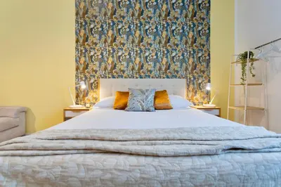 a bedroom with a large white bed with a wall at Flora Cozy Flat close to Metro in Rome