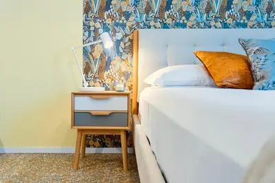a bedroom with a bed and a nightstand with a side table at Flora Cozy Flat close to Metro in Rome