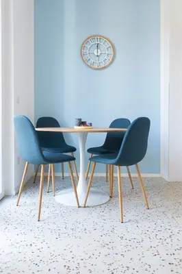 a table with four chairs and a clock on a wall at Flora Cozy Flat close to Metro in Rome