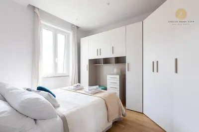 a white bedroom with a bed and a dresser at Giglio Dome View - St Peter View, 300mt to Metro A, Vatican City, A-C in Rome
