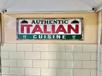 a sign for an authentic italian cuisine on a wall at A Casa di Gio in Rome