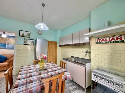 a kitchen with a table with a vase of flowers on it at A Casa di Gio in Rome