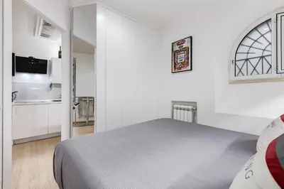 a white bedroom with a bed and a kitchen at Colosseum Charming Suite monti district with jacuzzi in Rome