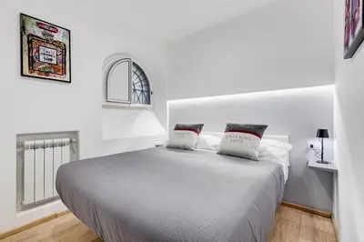 a white bedroom with a bed with two pillows at Colosseum Charming Suite monti district with jacuzzi in Rome
