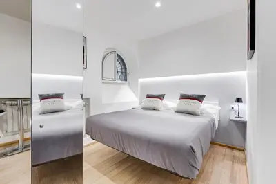 a white bedroom with a bed and a mirror at Colosseum Charming Suite monti district with jacuzzi in Rome