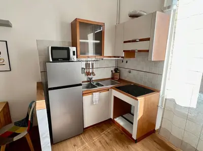 a small kitchen with a refrigerator and a sink at Casa degli Effetti in Rome