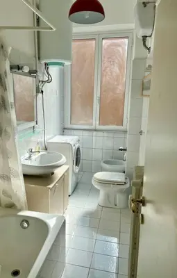 a white bathroom with a toilet and a sink at Casa degli Effetti in Rome