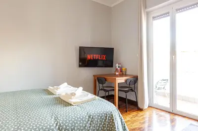 a bedroom with a bed and a table with a desk at Casa Cornelia 10 MIN to metro, near Vatican in Rome