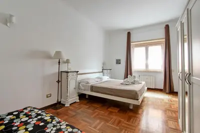 a white bedroom with a bed and a window at Elle House in Rome