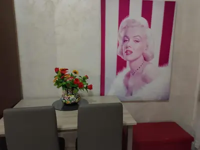 a table with a vase of flowers and a picture at Moon and Sun LT Apartament in Rome
