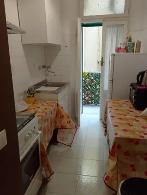 a kitchen with a table and a stove and a refrigerator at Moon and Sun LT Apartament in Rome