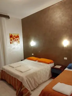 a bedroom with two beds with orange pillows at Moon and Sun LT Apartament in Rome