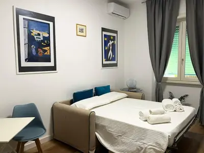 a bedroom with a bed and two blue chairs at Viale4Venti in Rome