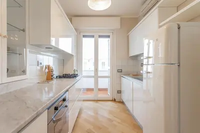 a kitchen with white appliances and a large window at Monteverde 2BDR Penthouse in Rome