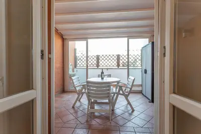 a dining room with a table and chairs and a window at Monteverde 2BDR Penthouse in Rome