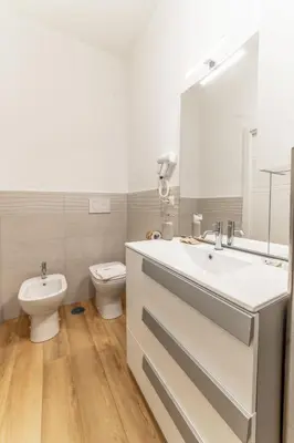 a bathroom with a sink and a toilet and a mirror at Lorena Cozy Rooms - Ospedale Gemelli - WiFi in Rome