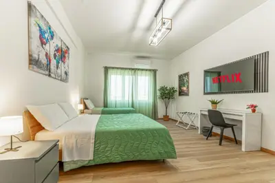 a bedroom with a green bed and a desk at Lorena Cozy Rooms - Ospedale Gemelli - WiFi in Rome