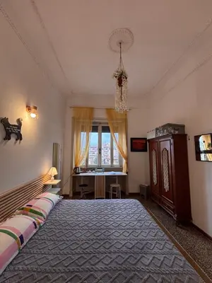 a bedroom with a bed and a desk and a window at La stanza di Marta in Rome