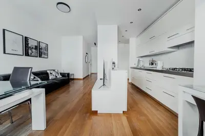 a white kitchen and living room with a black couch at Photographer's House in Rome