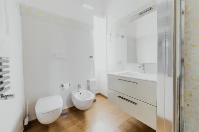 a white bathroom with a toilet and a sink at Photographer's House in Rome