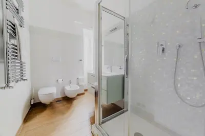 a bathroom with two toilets and a glass shower at Photographer's House in Rome