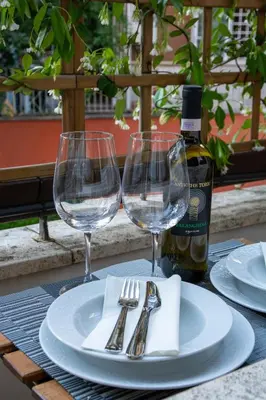 a table with two wine glasses and a bottle of wine at Photographer's House in Rome
