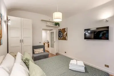 a white living room with a couch and a tv at Fresh House San Lorenzo in Rome
