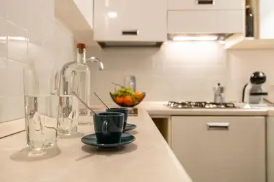 a kitchen counter with a bottle and cups on it at Appartamento Roma Coronari Suite in Rome