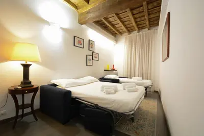two beds in a room with a lamp on a table at Appartamento Roma Coronari Suite in Rome