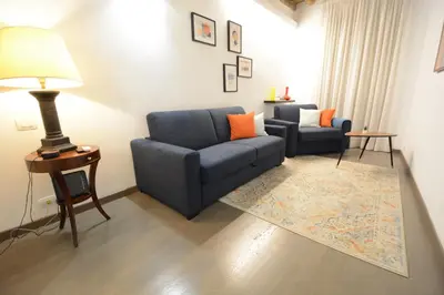 a living room with a blue couch and a chair at Appartamento Roma Coronari Suite in Rome