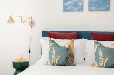 a bed with white pillows and a blue headboard at Appartamento di Design - Metro Re di Roma in Rome
