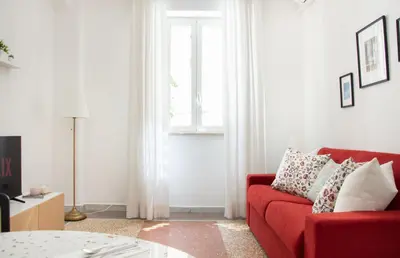 a living room with a red couch and a window at Appartamento di Design - Metro Re di Roma in Rome