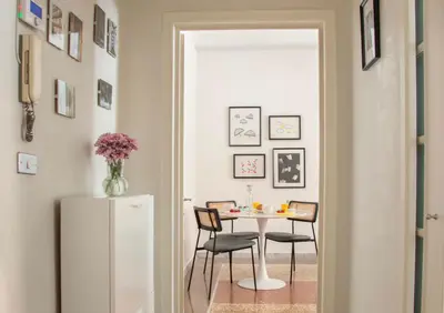 a dining room with a table and chairs and a refrigerator at Appartamento di Design - Metro Re di Roma in Rome