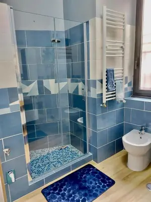 a blue tiled bathroom with a shower and a toilet at Happy Days \u5feb\u4e50\u7684\u65e5\u5b50 in Rome