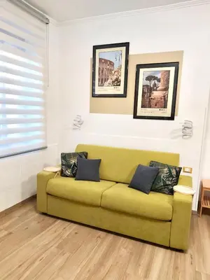a green couch in a living room with pictures on the wall at Happy Days \u5feb\u4e50\u7684\u65e5\u5b50 in Rome
