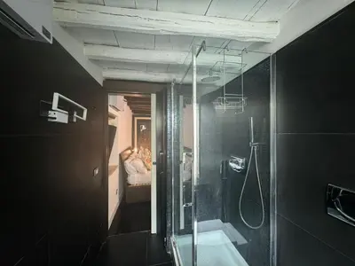 a bathroom with a glass shower and a sink at In Ancient Rome Apartment in Rome