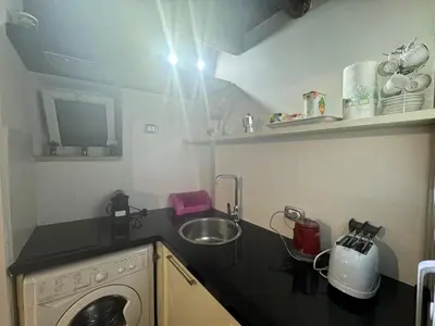 a small kitchen with a sink and a washing machine at In Ancient Rome Apartment in Rome